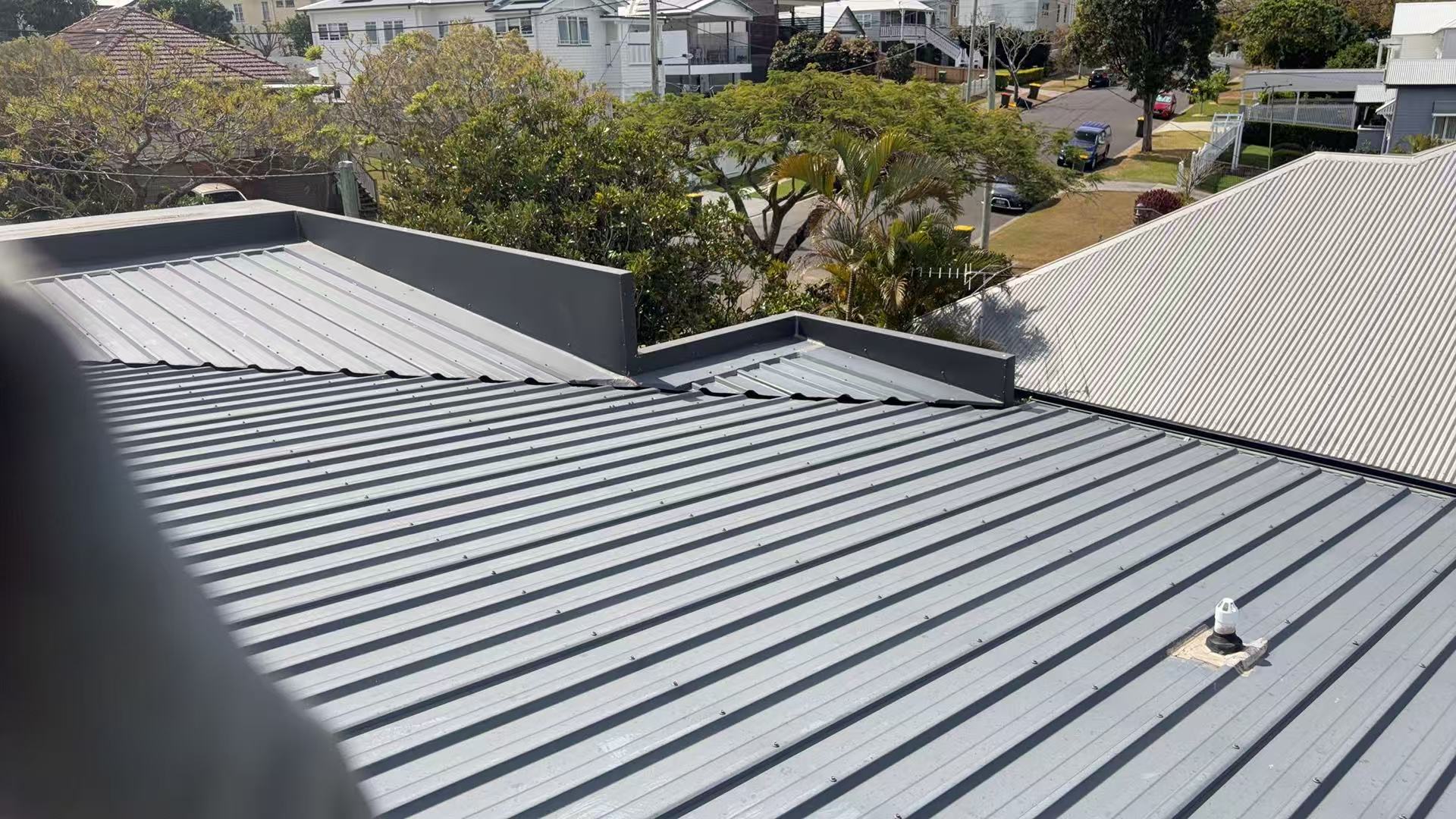 Grey metal roof planes and adjoining flashing lines
