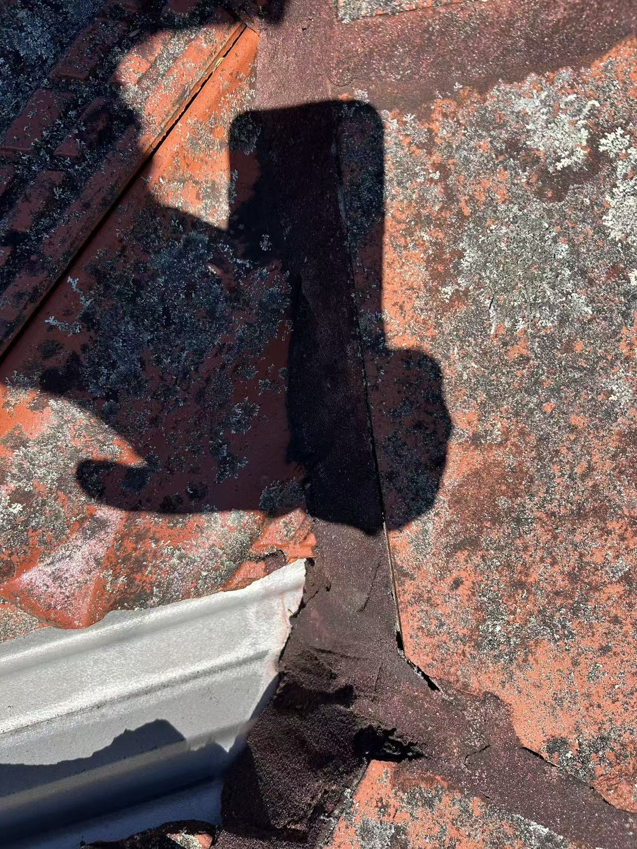 Flashing at a tiled roof junction with cracked adjoining mortar